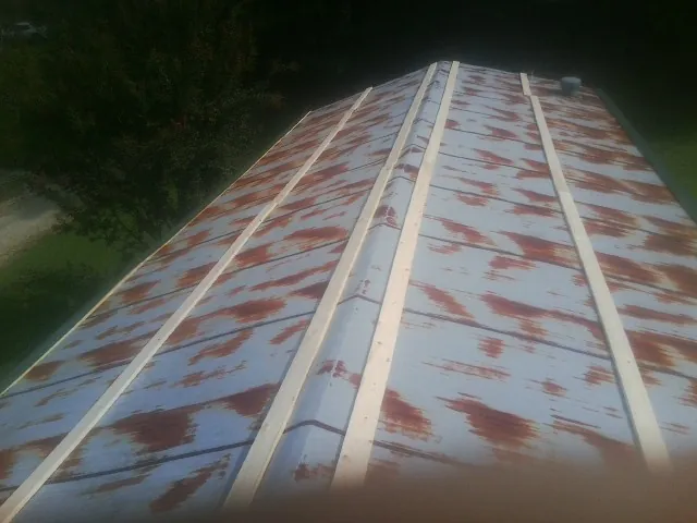 Rusted metal roof panels with new wood purlins before replacement — Storm Damage Roof Repair in Grimes by Roofing Brothers